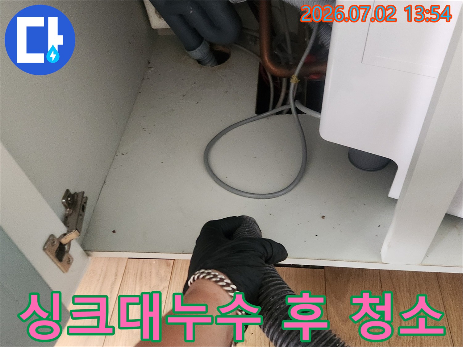 싱크대 누수 공사 후-작업자가 석션 장비로-하부장의 물기를 제거하는 모습