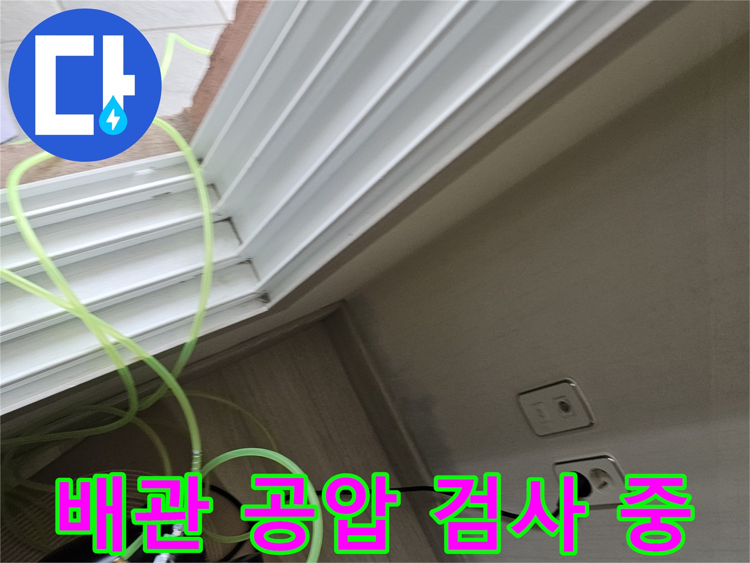 벽면 콘센트 아래로 연결된 노란색 배관 테스트 호스