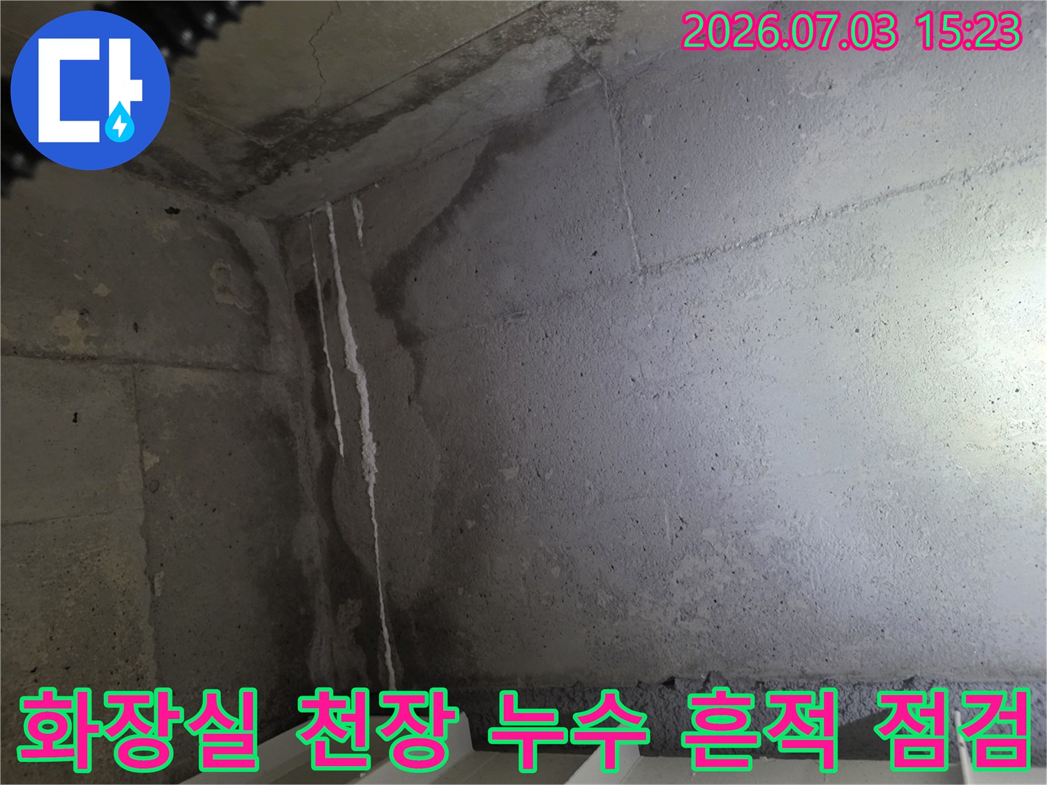 콘크리트 벽면에 하얀 석회 고임과 물이 흘러내린 자국이 선명하게 보이는 화장실 천장 내부 모습