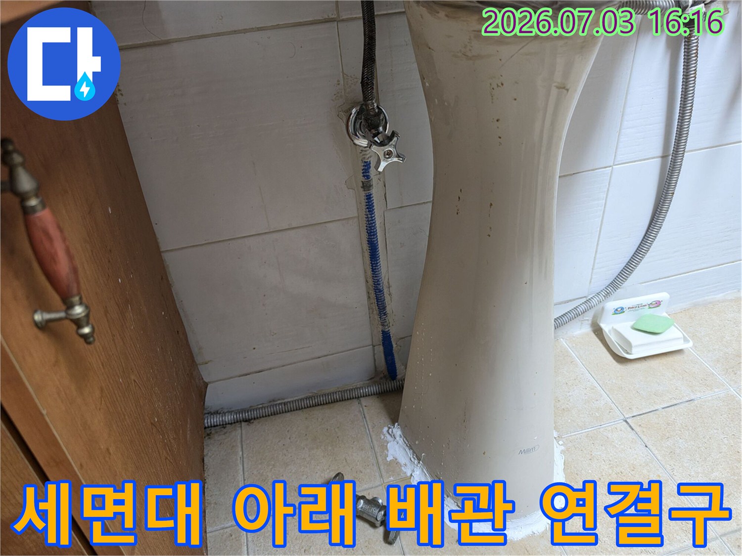 세면대 아래쪽의 복잡한 배관 구조와 연결 부위를 상세히 검사하는 사진