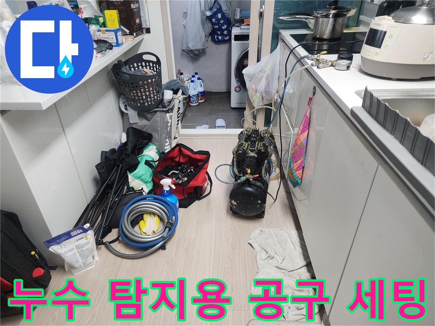 싱크대 밑 작업 공간에 정리된 배관 점검용 도구와 압력계