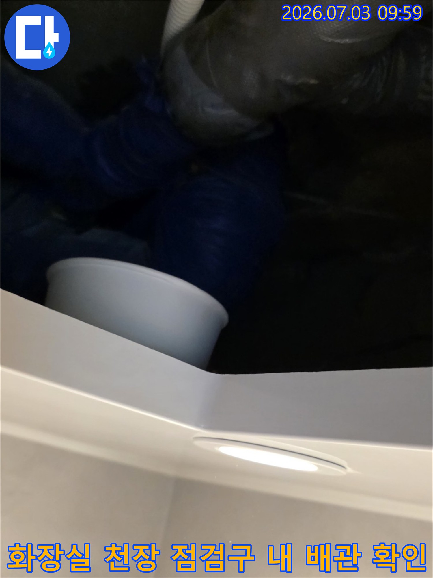 화장실 천장 점검구를 열고 노후된 배관 연결 부위를 점검하는 모습
