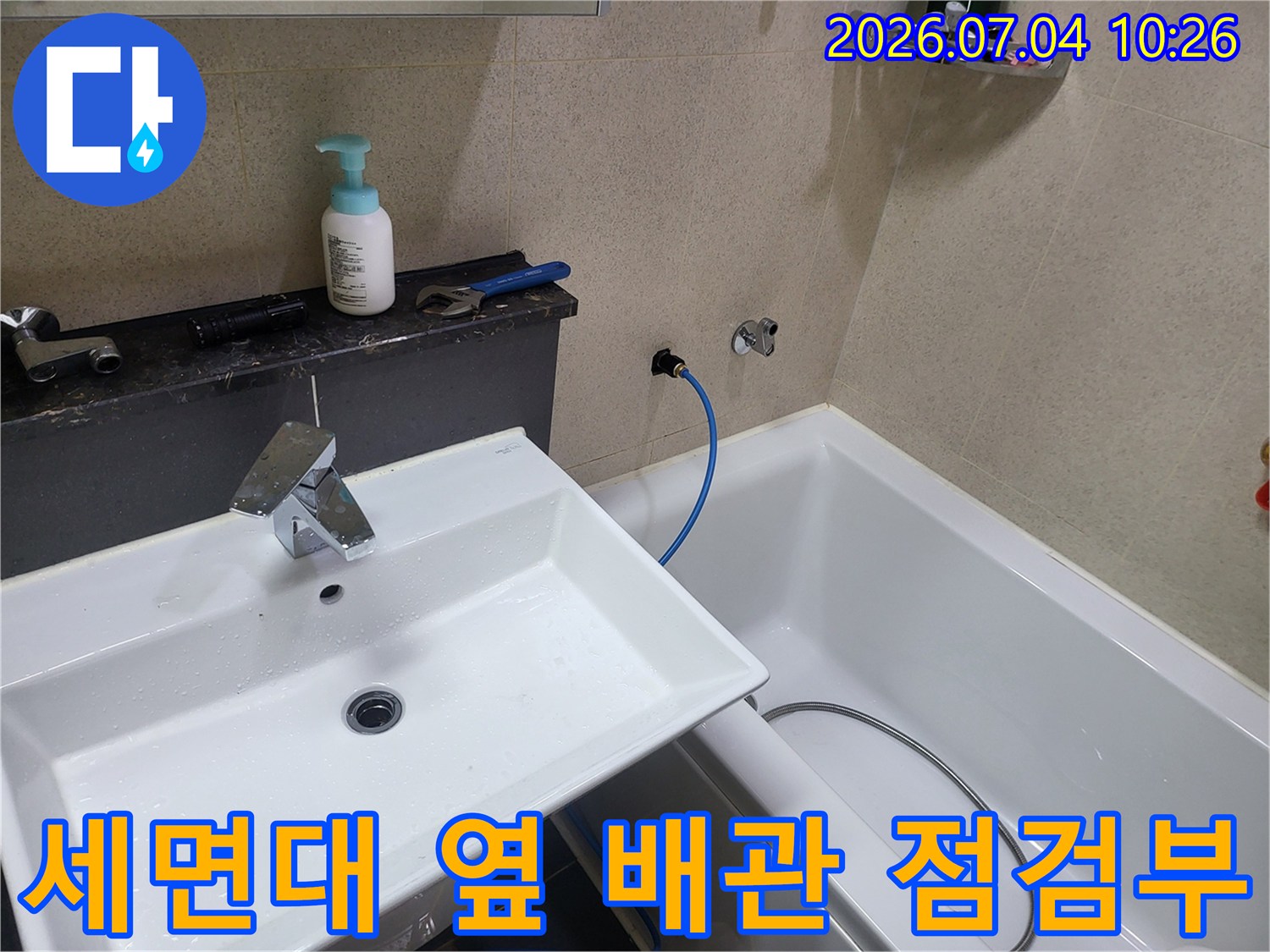 욕조와 세면대 사이 공간에 위치한 노출형 배관 및 호스 연결부 확인 과정
