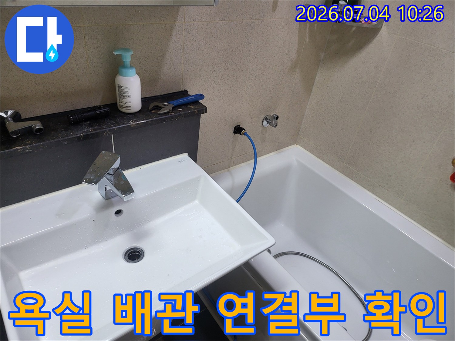 파란색 호스가 꺾인 구간과 세면대 하단 배관을 점검하는 장면