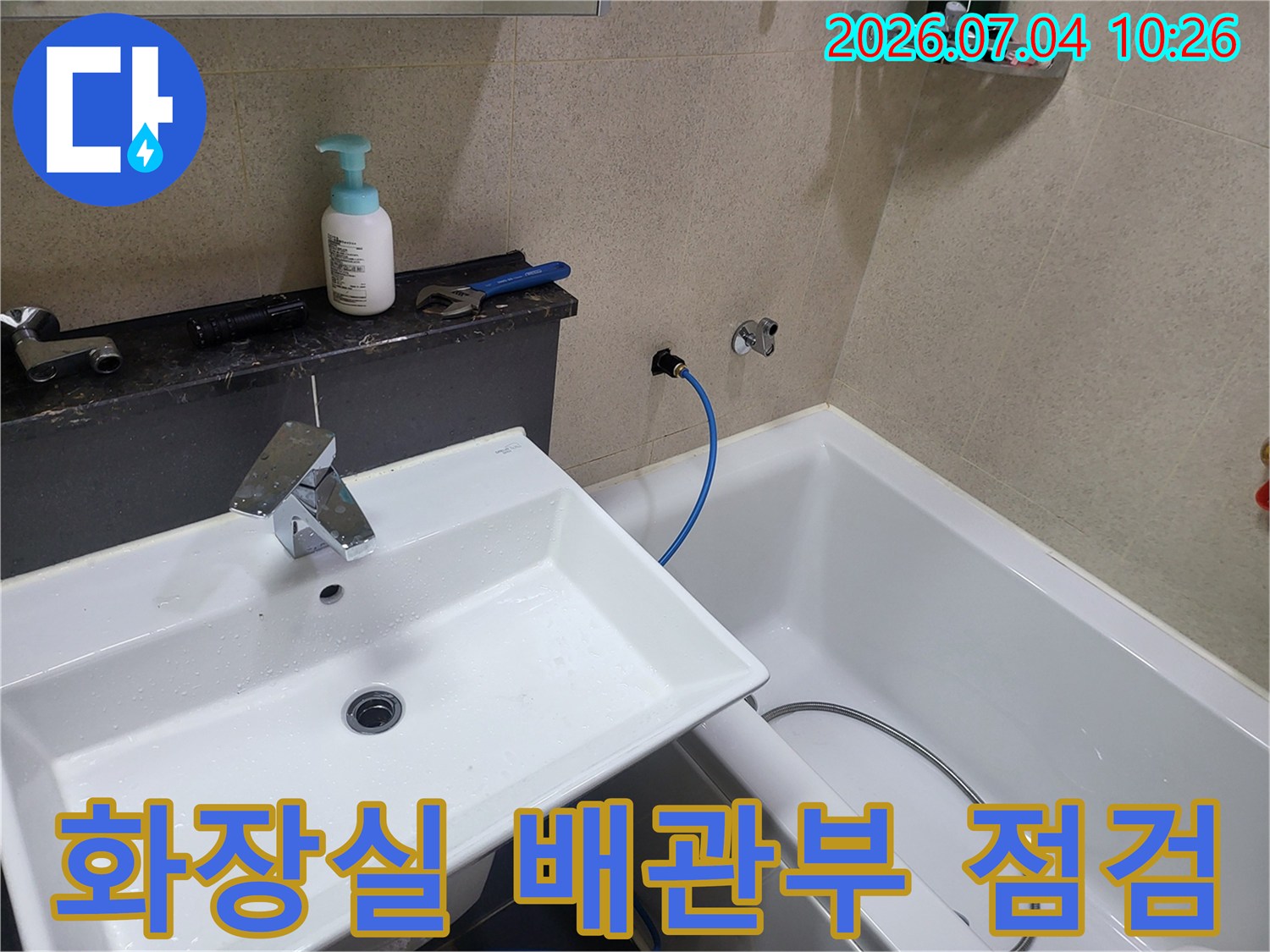 파란색 호스와 세면대 연결 부위를 포함한 화장실 내 노출 배관 점검 모습