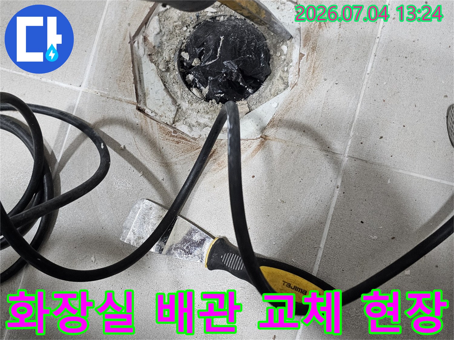 화장실 바닥 타일을 걷어낸 후 노출된 배관에 전문 장비를 연결하여 점검하는 모습
