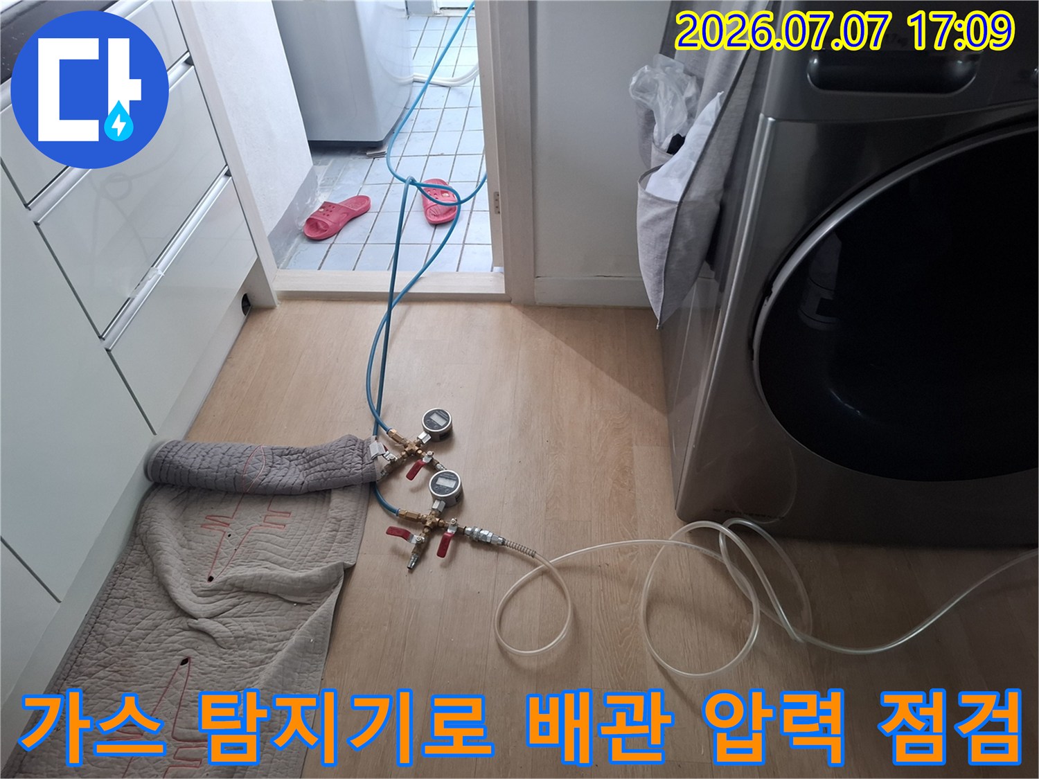 고성능 가스 탐지 장치를 연결하여 세탁실 내부의 수도 배관 누수를 정밀하게 측정하는 모습