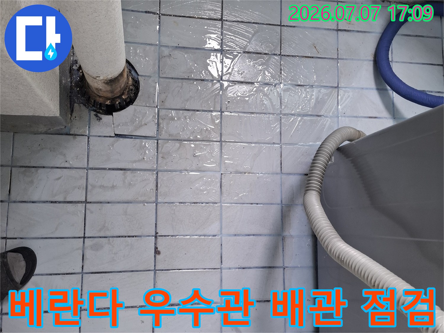 노출된 우수관 주변의 타일과 배관 연결 부위를 점검하는 모습