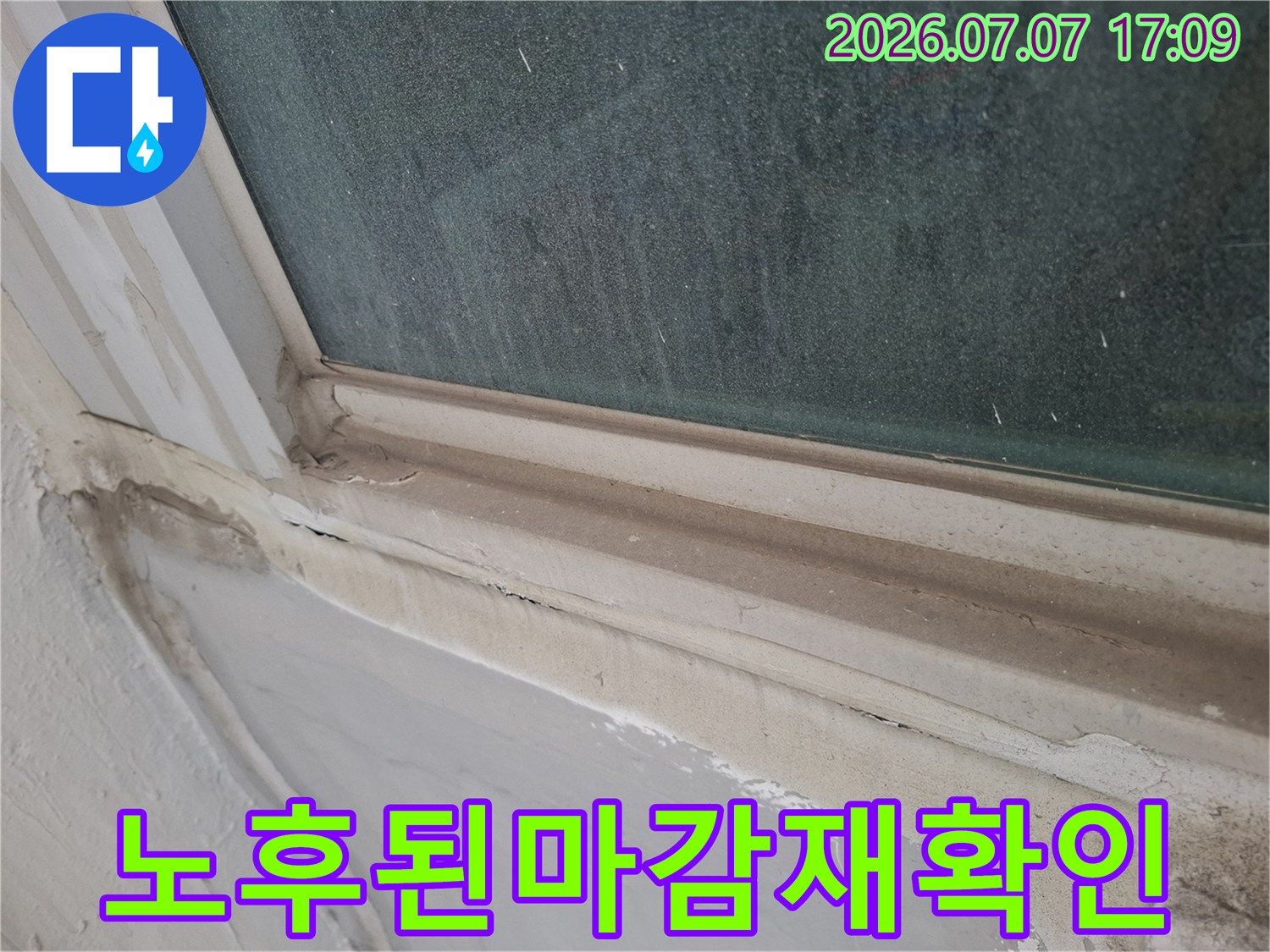 베란다 창틀 하단의 노후화되고 오염된 마감재와 우수관 주변 상태를 촬영한 사진