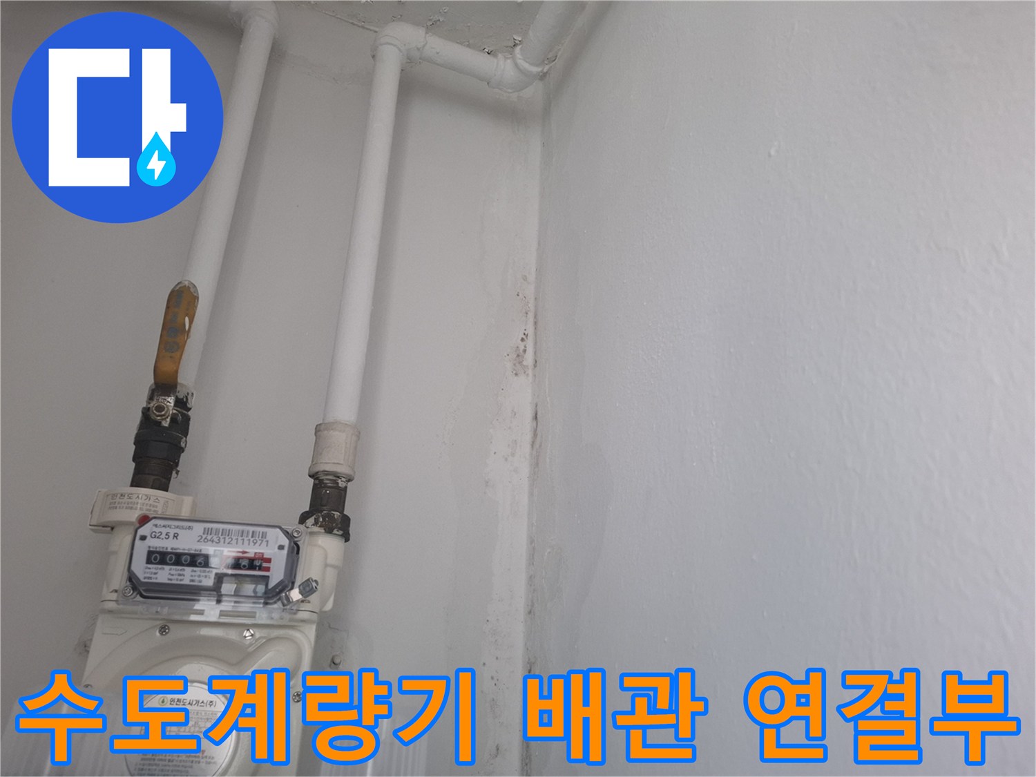 흰색 PVC 배관과 금속 밸브가 연결된 계량기 사진입니다.