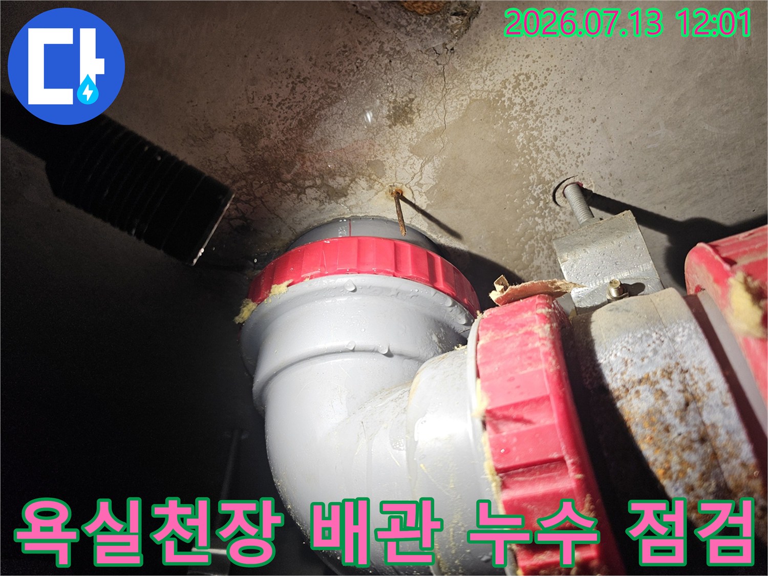 노후된 배관 연결 부위와 천장 콘크리트 슬래브의 습기 오염 상태