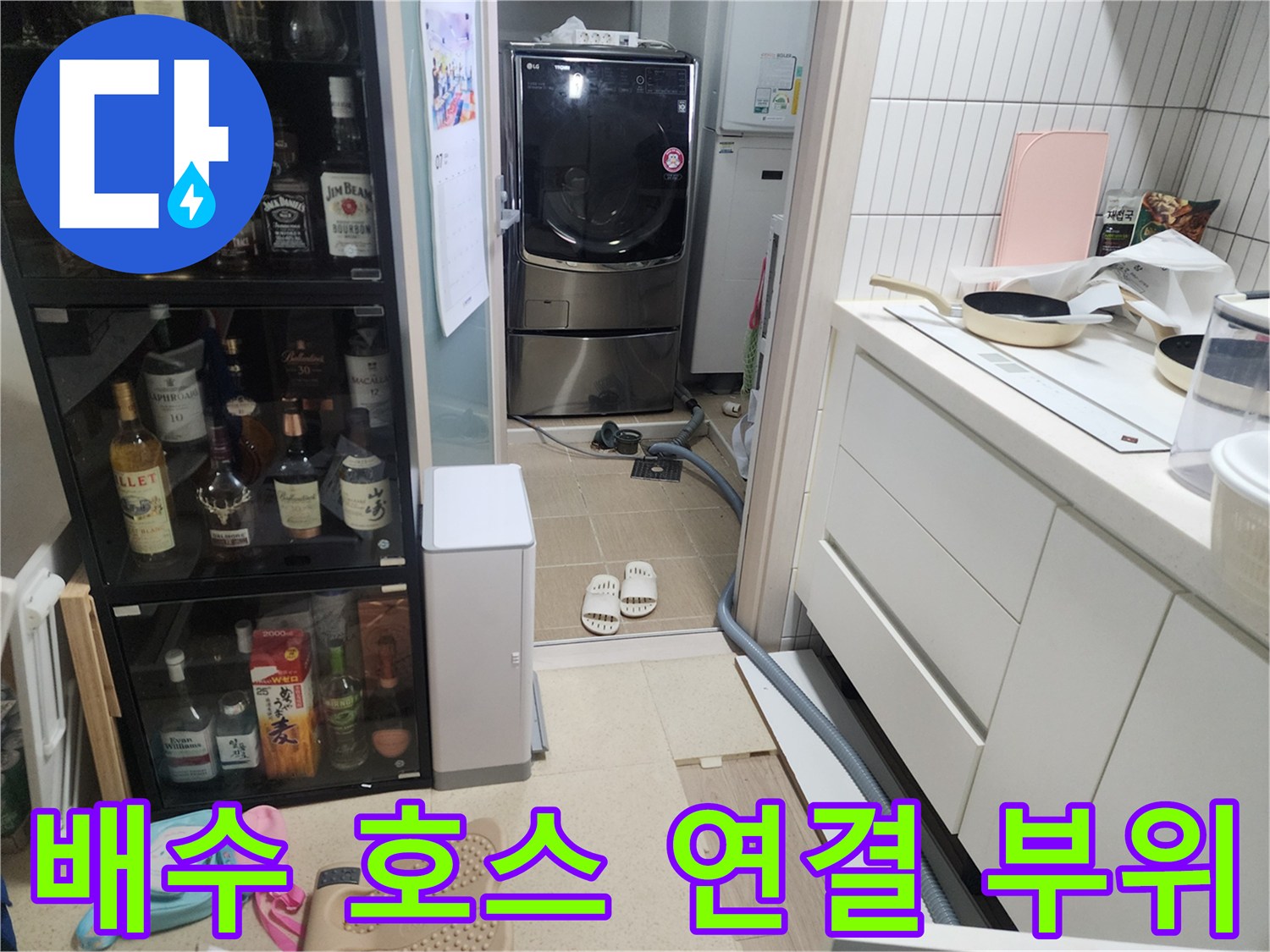 싱크대 하부 배관과 세탁기 배수 호스가 위치한 바닥 타일 구간