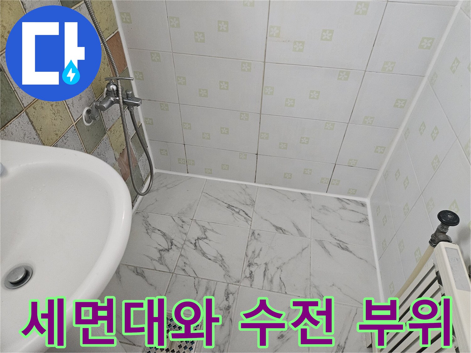 수전과 샤워기 호스가 연결된 세면대 주변의 모습입니다.