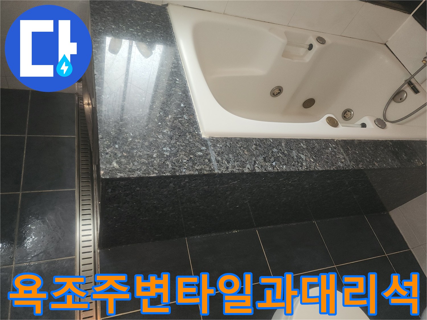 검은색 대리석과 타일로 이루어진 욕조 주변부 모습
