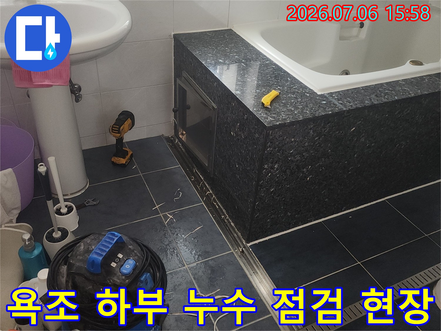 욕조 아래 배관과 장비를 배치하여 정밀하게 누수를 점검하는 장면