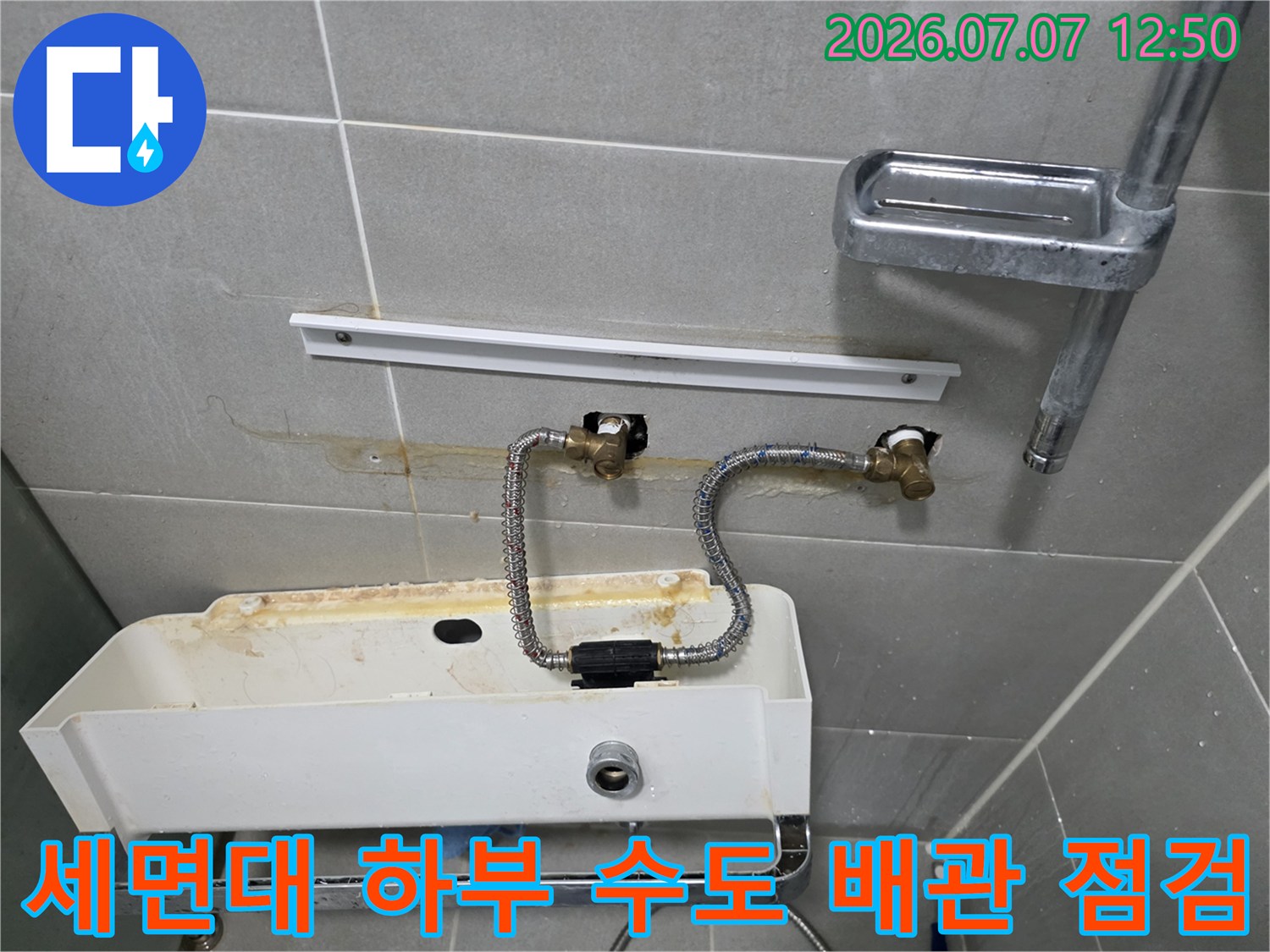 벽체 밸브와 연결된 노출형 수전 호스의 누수 여부를 확인하는 현장 사진