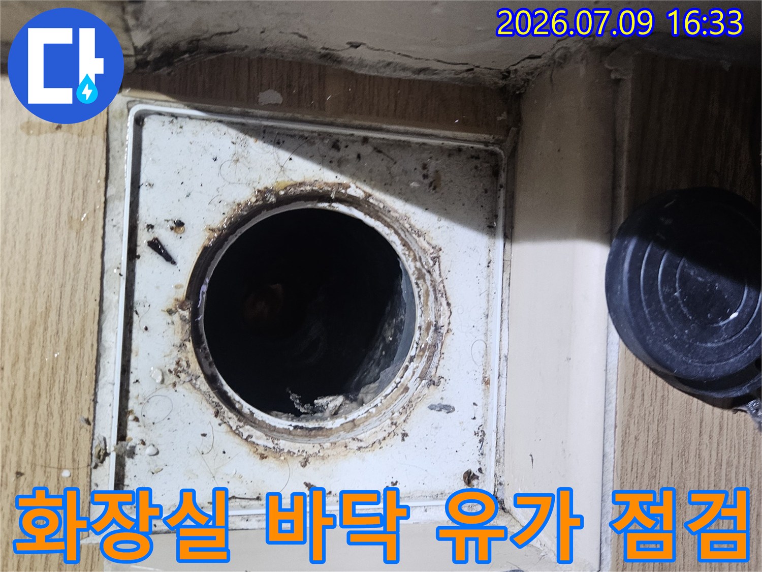 욕실 배수구(유가) 주변의 마감 상태와 노후된 시멘트 부분들을 정밀하게 확인하는 사진