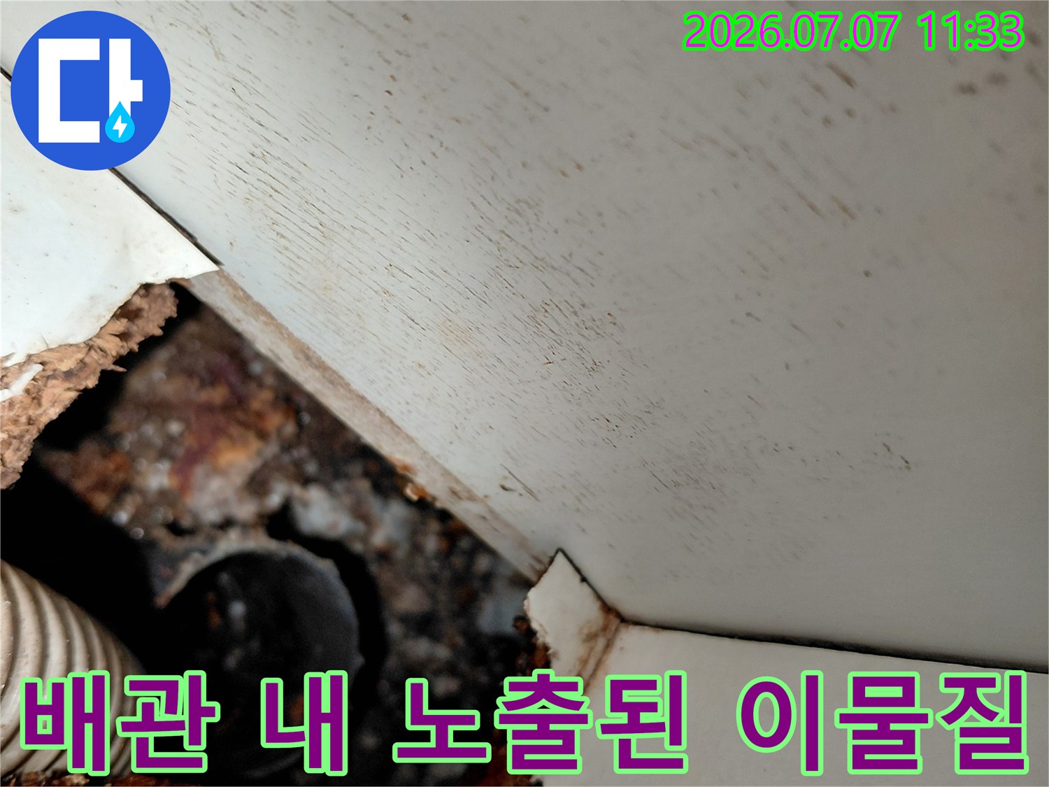 싱크대 아래 배관 부위가 오염물로 막혀 있는 상태를 촬영한 사진