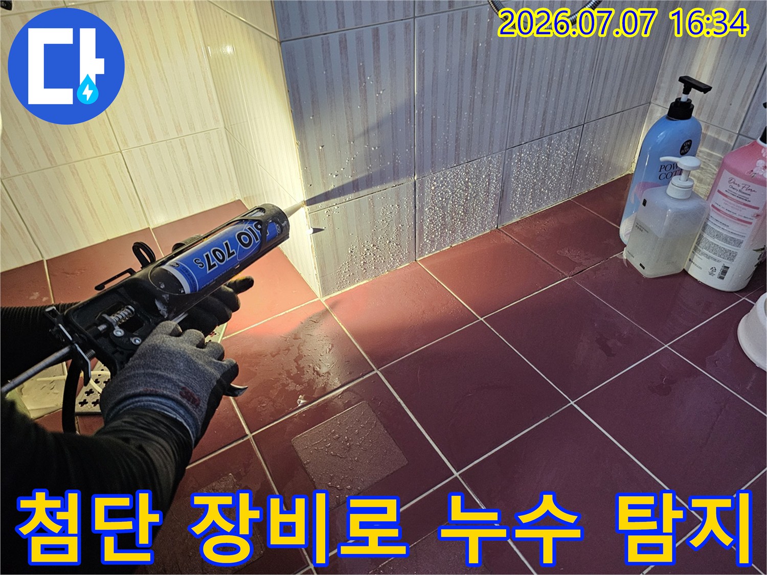 고성능 탐지기를 사용하여 화장실 타일 사이와 벽면 연결부를 꼼꼼하게 검사하는 모습