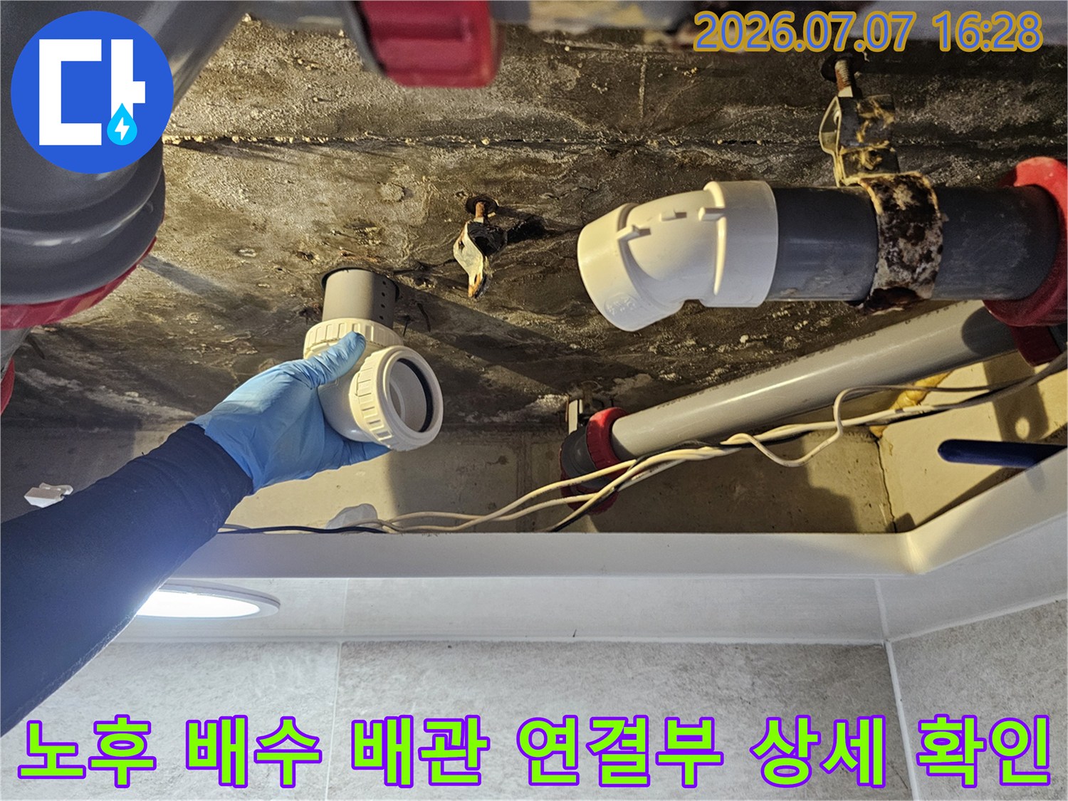 손상된 화장실 천장 내 배출 배관의 접속 부위를 세밀하게 진찰함