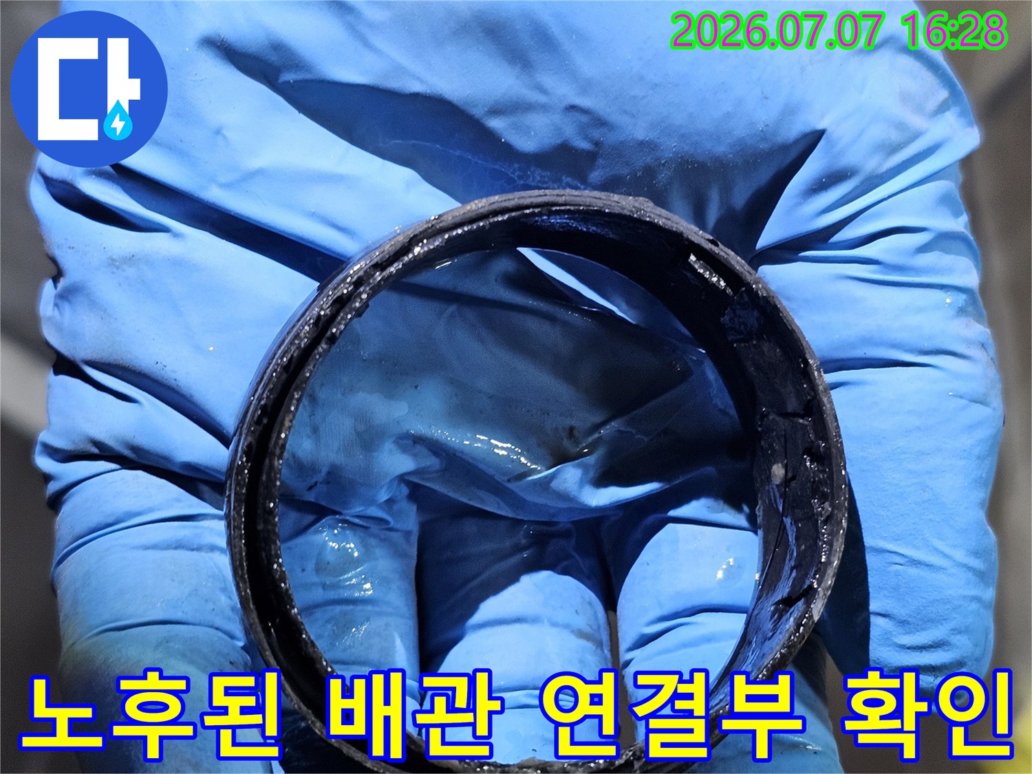 작업자가 장갑을 끼고 화장실 천장 내 노출된 배출 배관의 부식 상태를 진단하는 모습