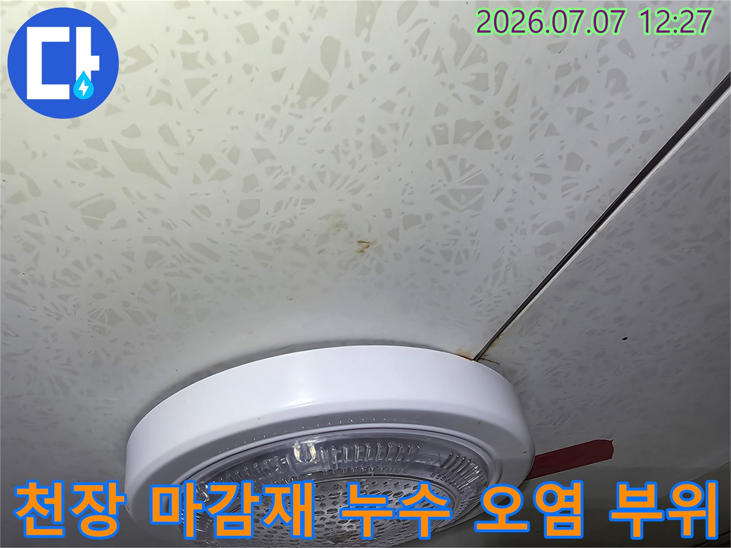 조명 기구가 설치된 천장 영역에 나타난 누수의 흔적과 변색 상태