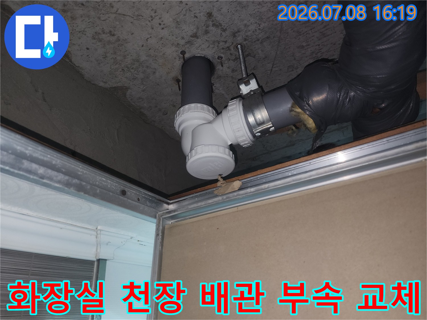 노후된 화장실 하수 배관 연결 부위의 파손된 부속을 제거하고 새 제품으로 교체하는 장면