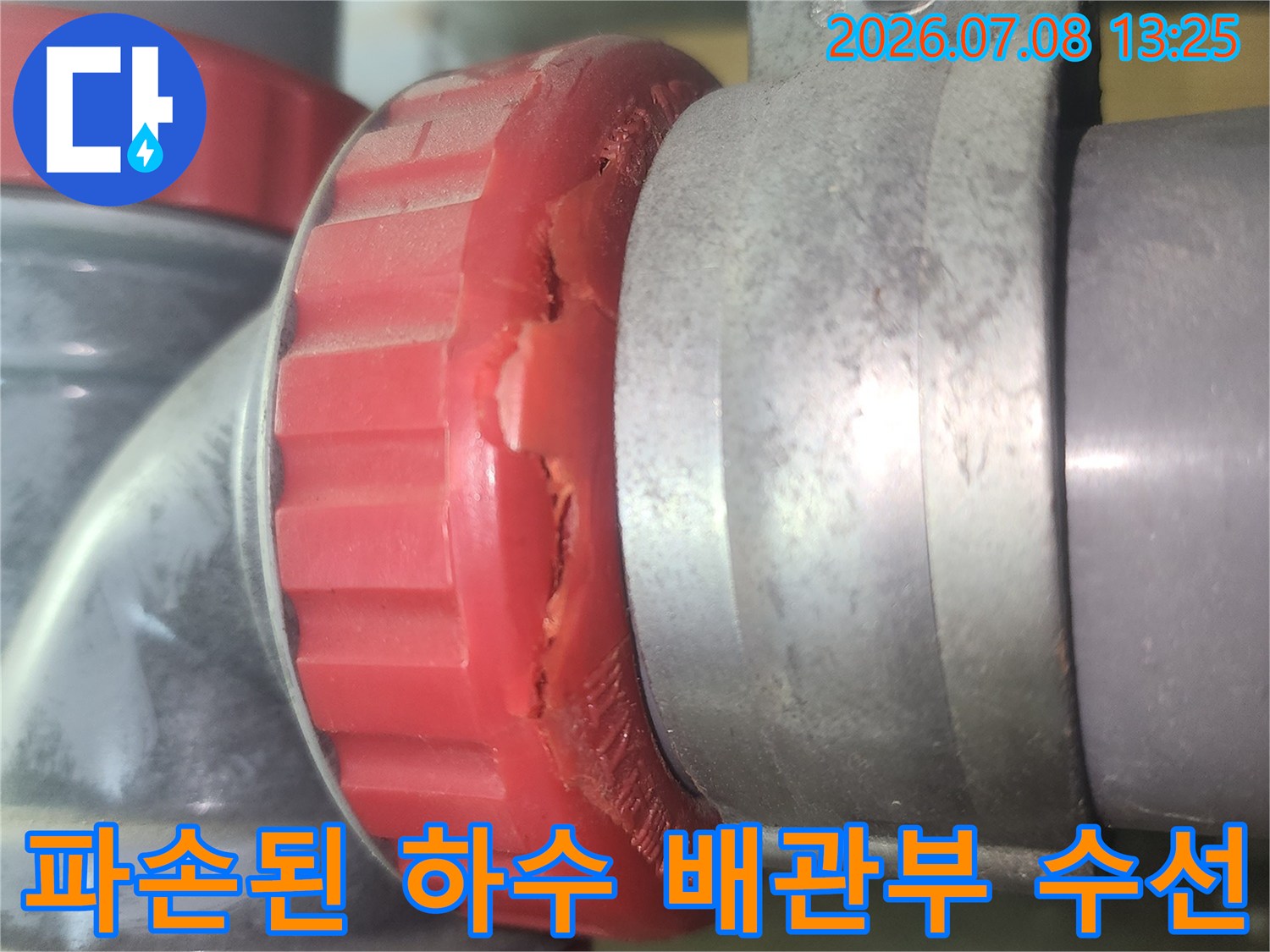 붉은색 덮개 소재구가 파손되어 누수가 발생하는 배관 연결 부위