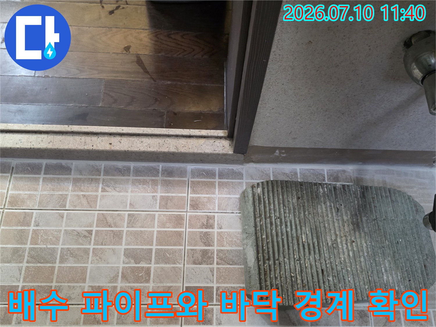배수구 주변의 타일과 배관 연결부를 세밀하게 점검하는 모습