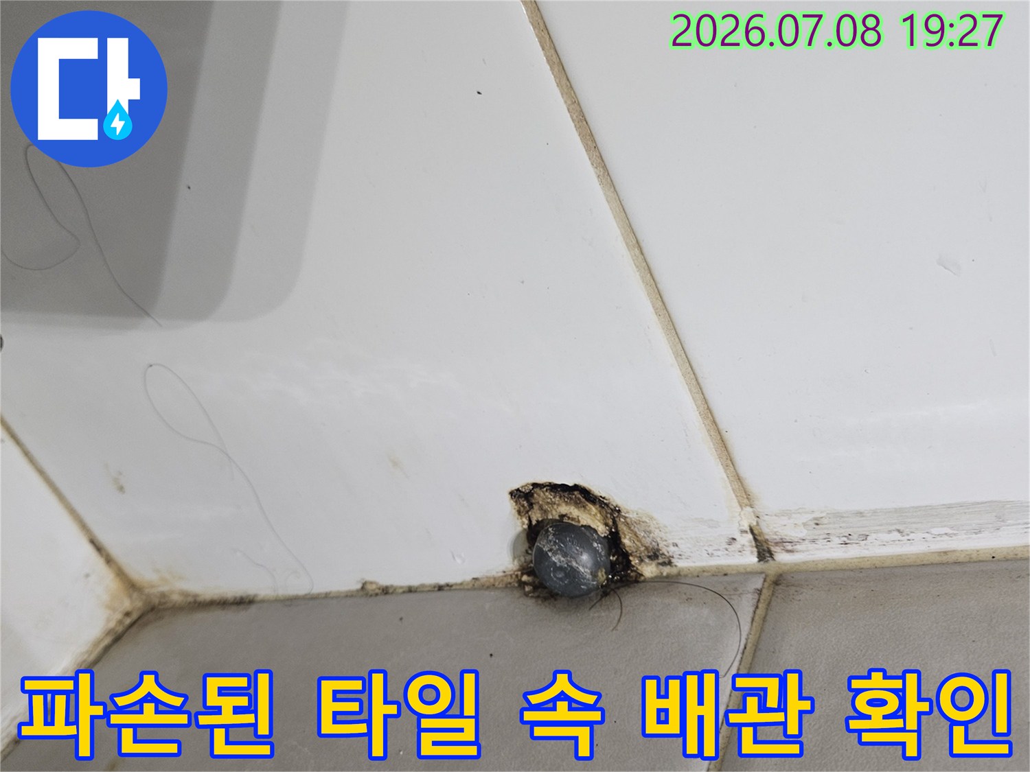 타일이 파손되어 노출된 배관 연결 부위의 누수 점검 상태