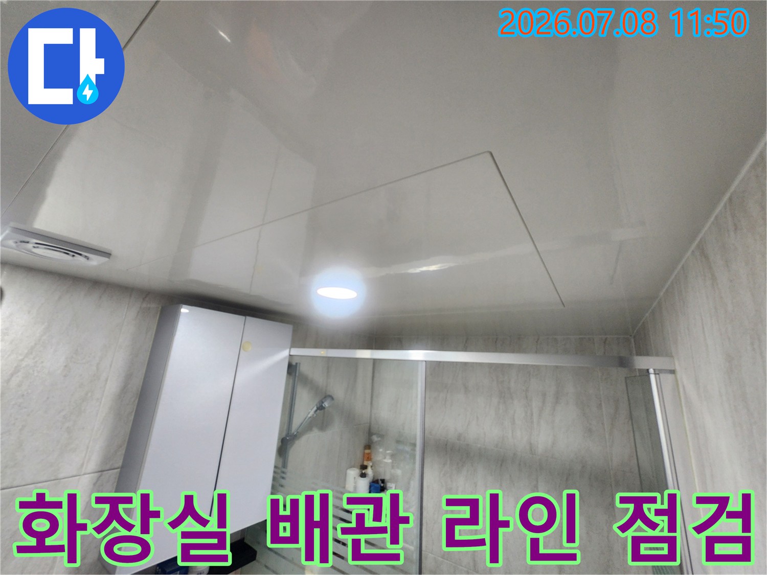 천장 내부 하수 배관의 연결 부위를 확인하고 수리 계획을 세우는 모습
