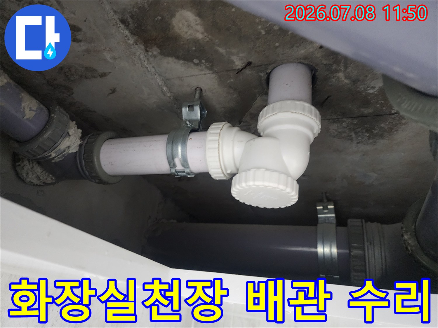 화장실 천장 내부의 노출된 하수 배관과 연결 부위 점검 장면