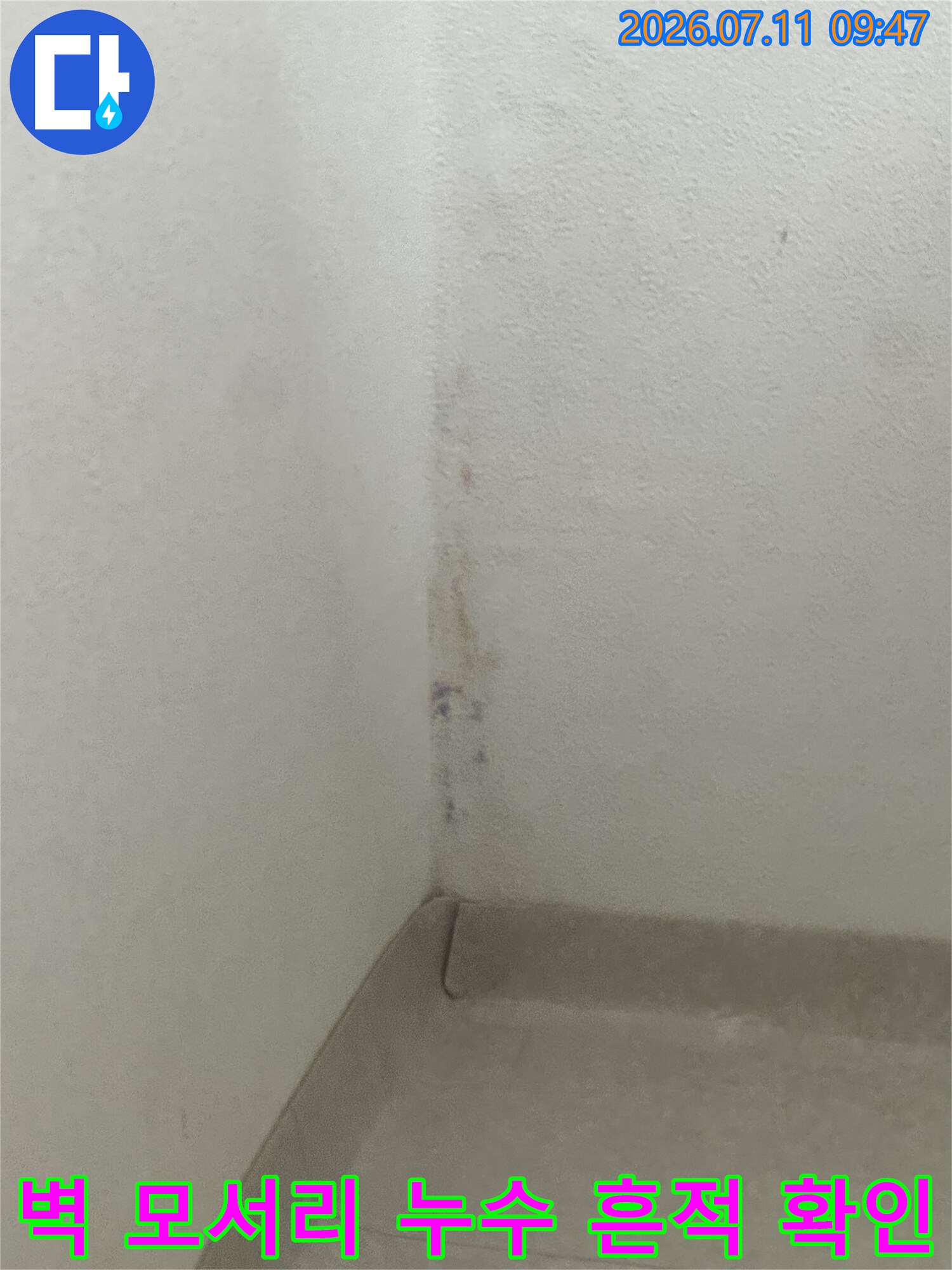 벽면 모서리에 길게 남은 습기 및 배수 관련 오염 부위