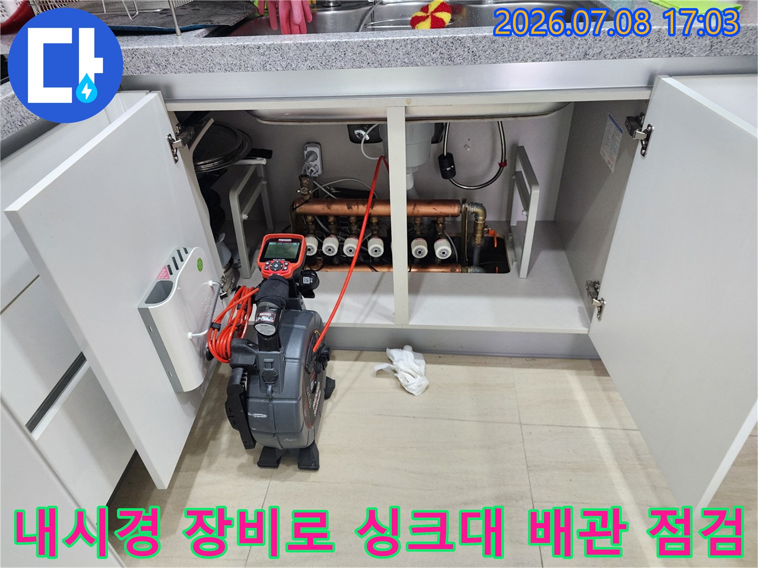 싱크대 하부장에 내시경 카메라를 투입하여 배관 내부 상태를 정밀하게 진단하는 장면