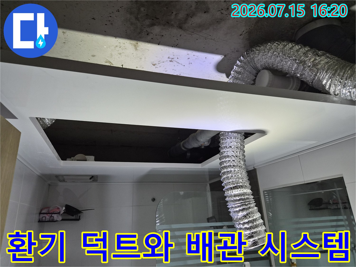 은박으로 덮인 환풍기 연결 배관과 노출된 천장 내부 구조