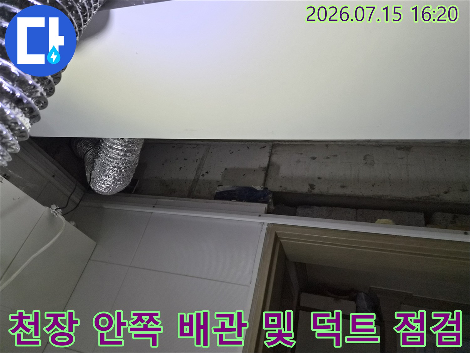 은색 금속 재질의 환기 시설과 상부 배수 라인이 노출된 천장 내부