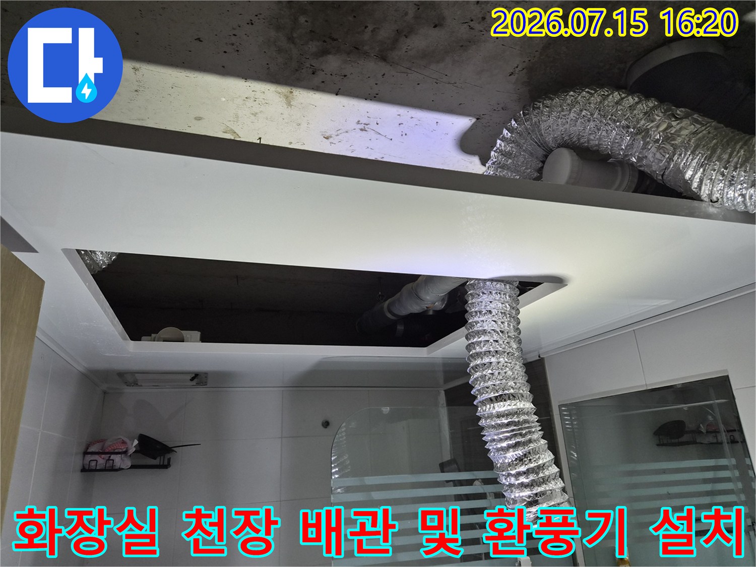 화장실 천장 내부의 은색 자재로 감싼 배관과 새롭게 설치된 환풍 장치 모습
