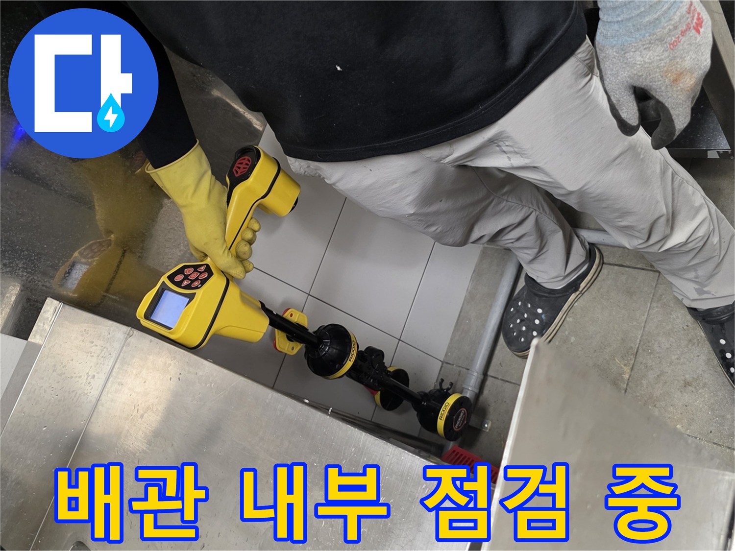 노란색 내시경 장비와 연결된 케이블이 배수구 안으로 들어가는 모습