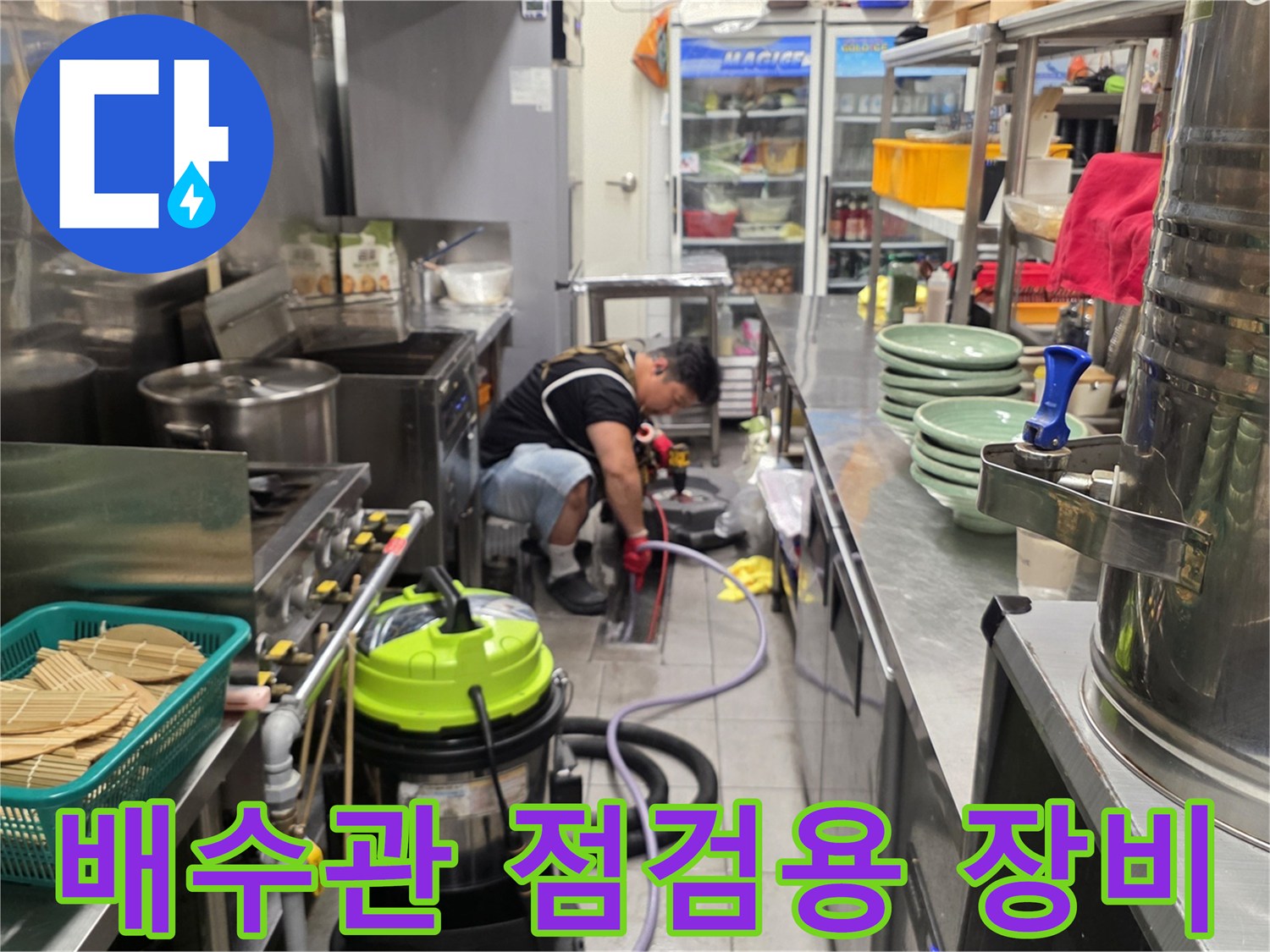 식당 주방 바닥에 배치된 배관 진단 및 흡입용 장비 세트