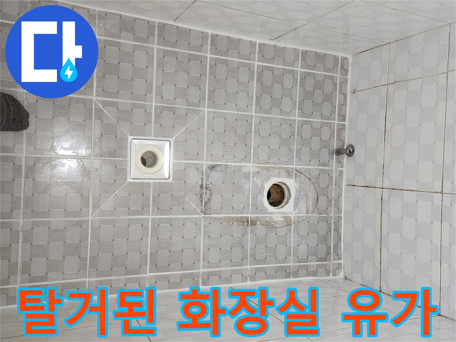 배수구 주변의 오염된 타일과 노출된 하수관 연결부