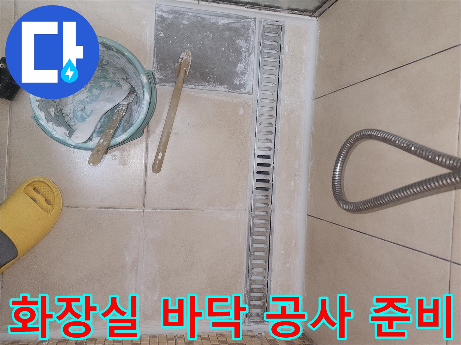 욕실 배수 트렌치와 유가 주변 타일을 제거하여 드러낸 작업 현장