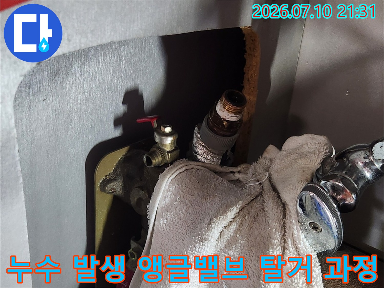 싱크대 아래 온수 배관용 앵글밸브를 제거하고 교체 준비하는 장면