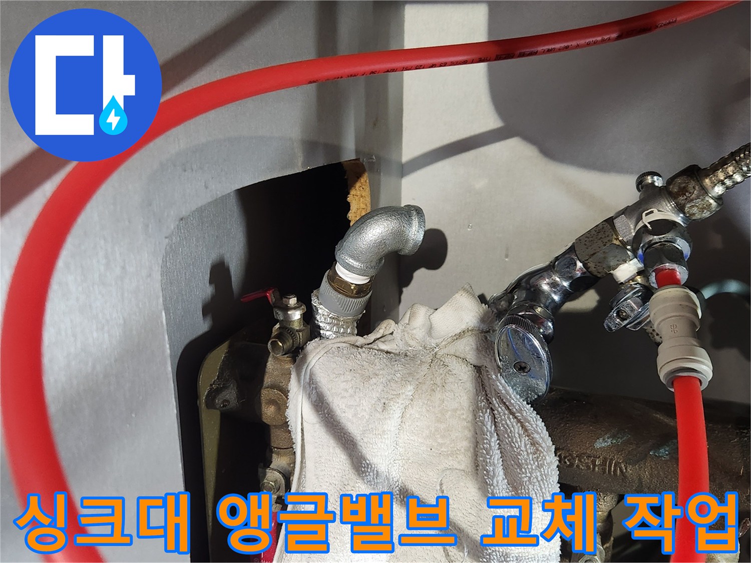 싱크대 하부 배관의 엘보우 부속과 앵글밸브 연결 상태를 보여주는 사진입니다.