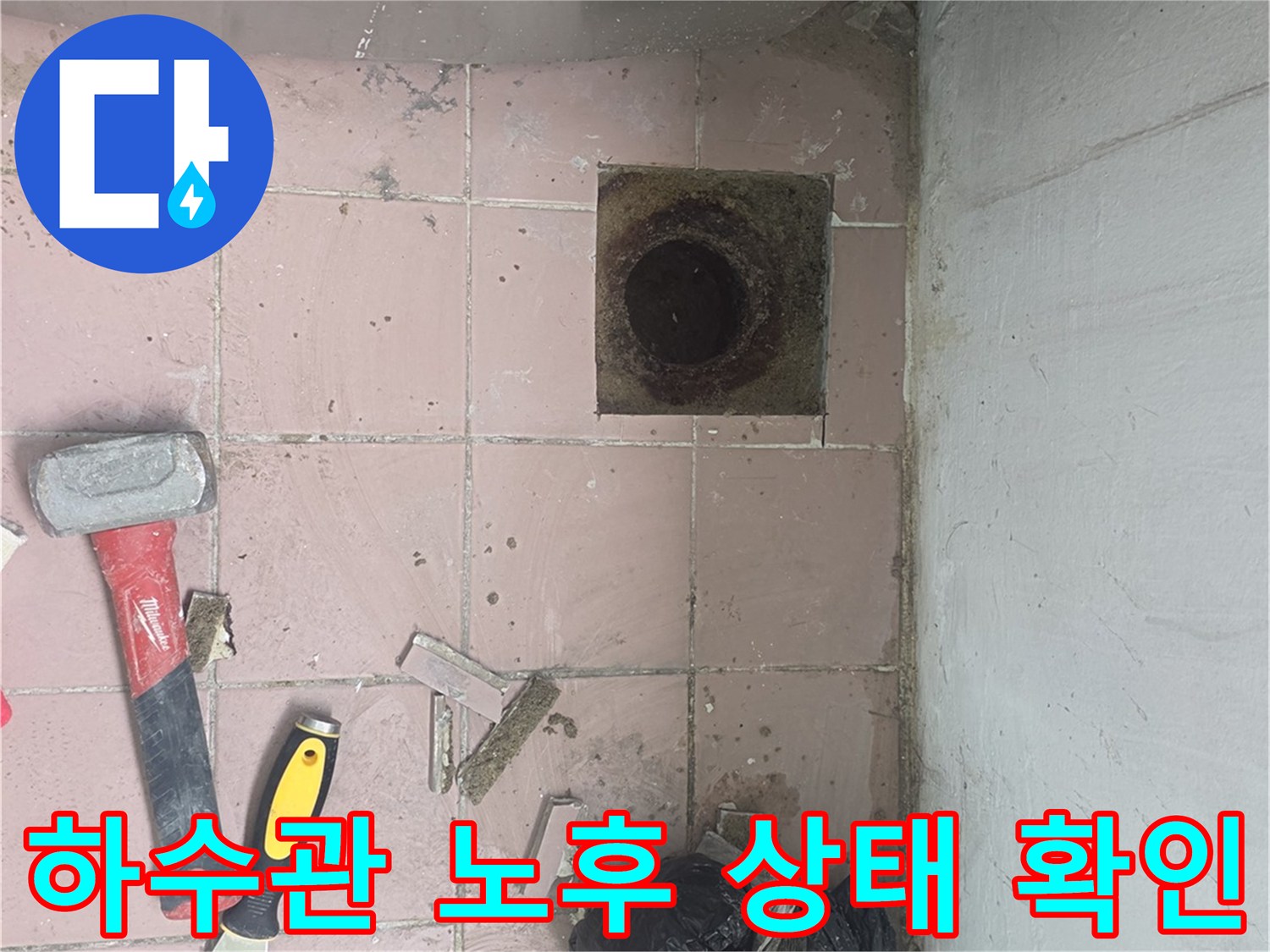 배수구 주변의 파손된 타일과 노출된 하수관 연결 부위