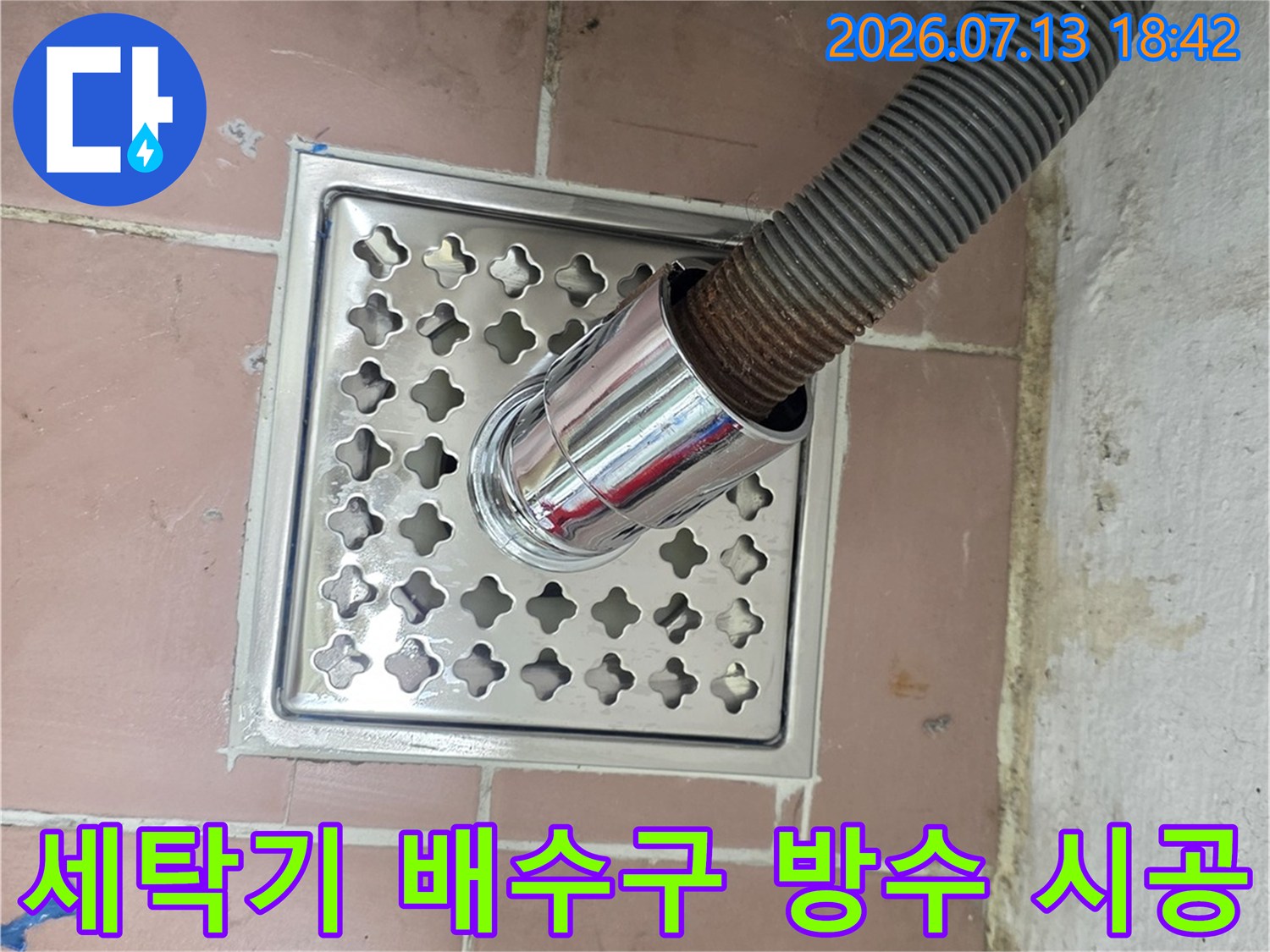 스테인리스 거름망과 배수 호스가 연결된 세탁실 바닥 유가