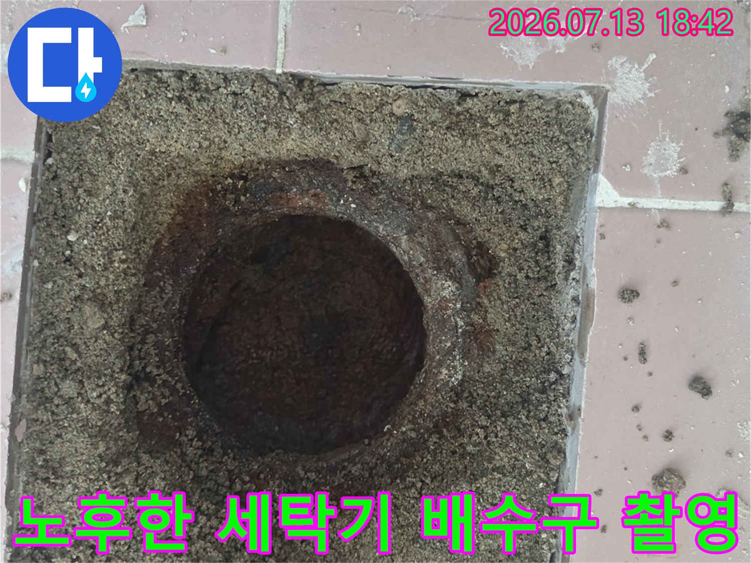 오염되고 노후된 타일 위의 세탁실 배수 트랩 위치와 상태
