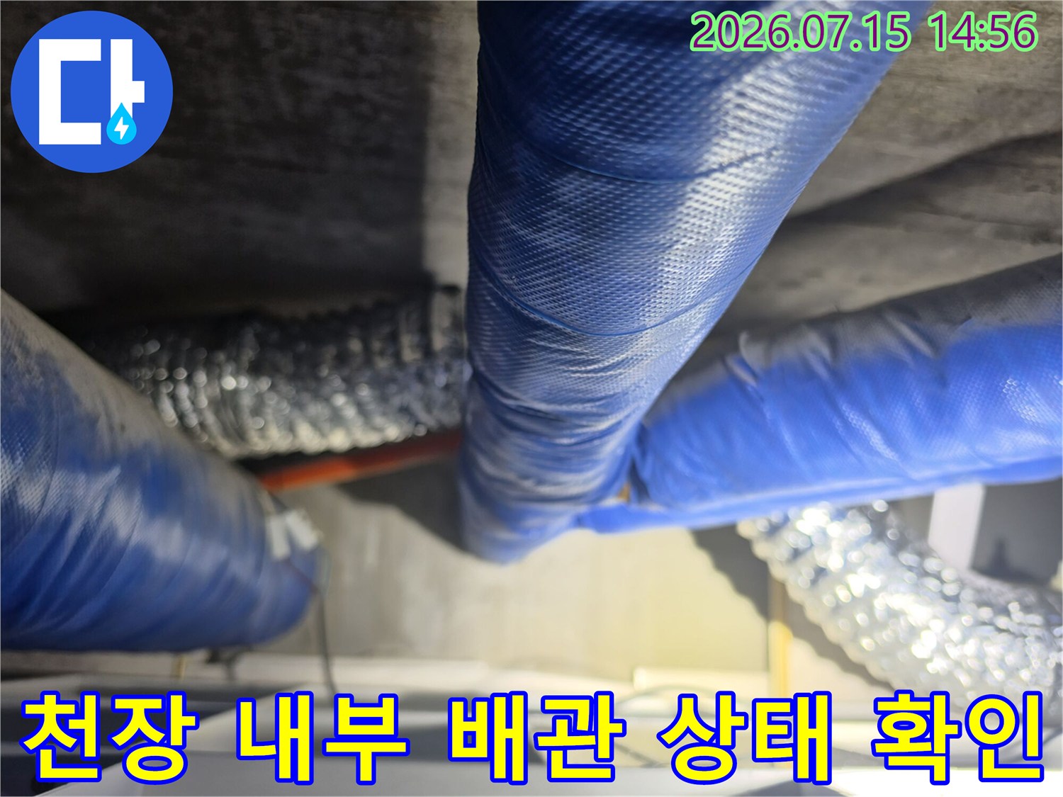 천장 내부에 노출된 파란색 보온재 배관의 연결 부위를 점검하는 모습