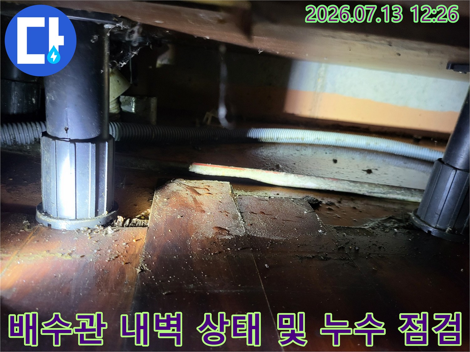 싱크대 밑 배출용 배관과 가림막을 사이에 두고 진행하는 정밀 진단 모습