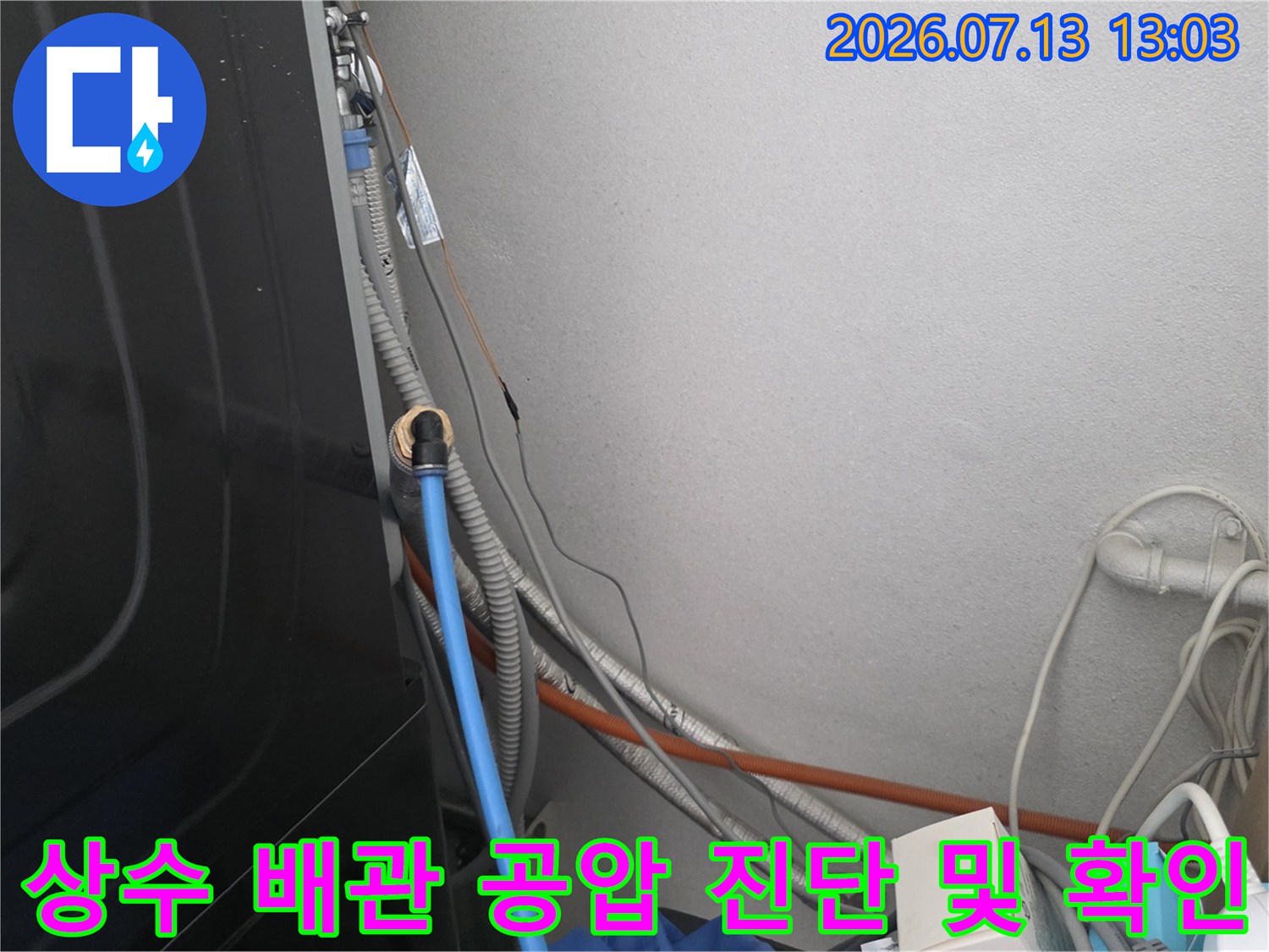 공압 테스트용 호스와 게이지를 활용해 상수 배관의 누수 여부를 점검하는 장면