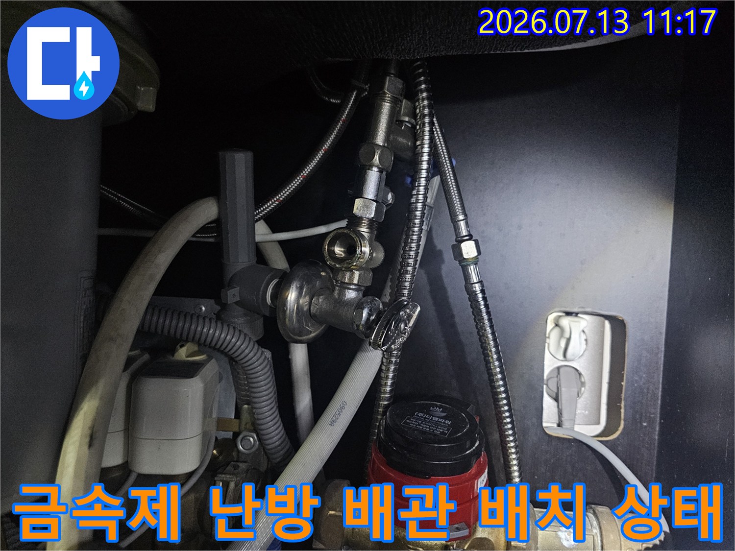 은색 금속 호스가 여러 갈래로 연결된 보일러 하부-배관 구조 사진